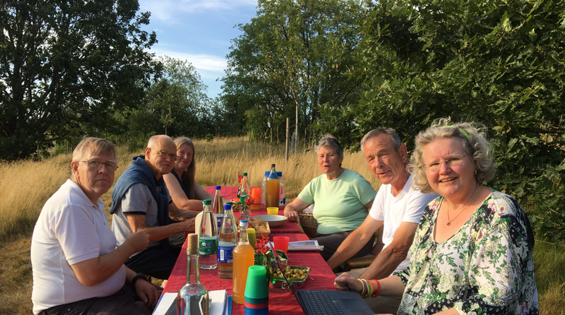 Mitglieder des BUND Kreisvorstands sitzen an einem Tisch auf einer Streuobstwiese